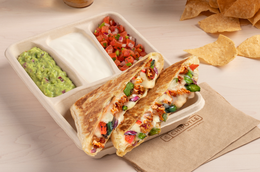 A plant-based Sofritas Fajita Quesadilla with a side of hand-mashed Guac, Sour Cream, and Fresh Tomato Salsa.